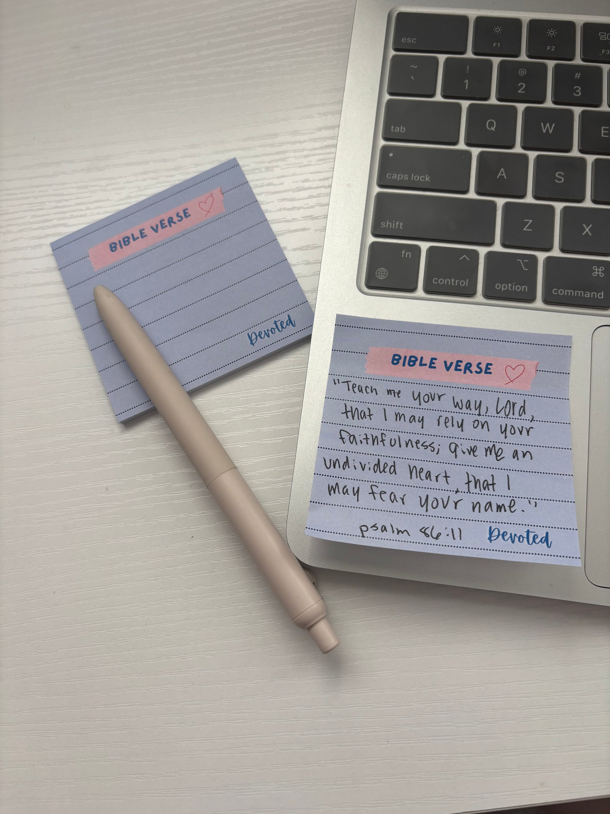 Notebook with 'Bible Verse' sticky notes on a laptop keyboard