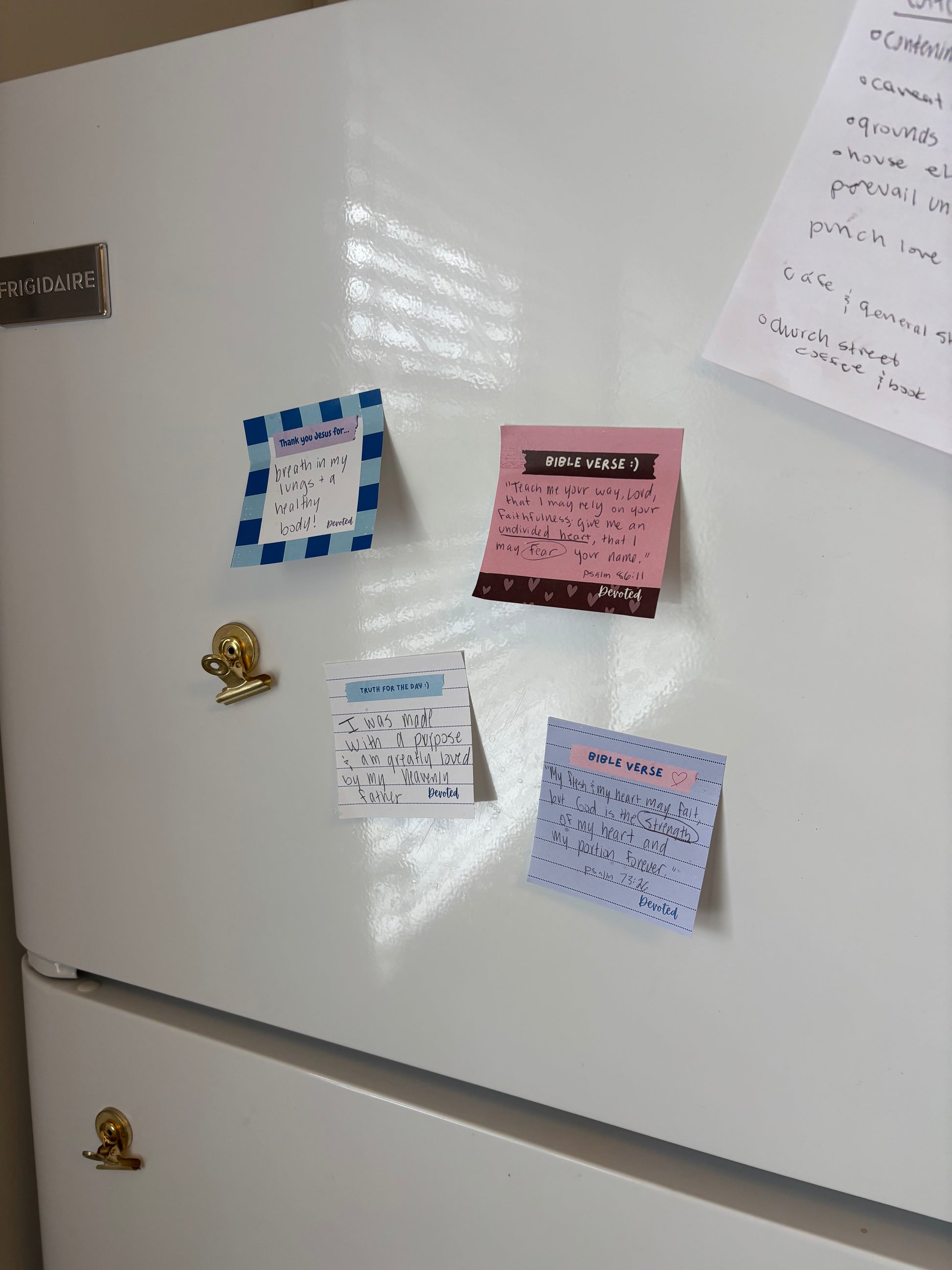 White refrigerator with various notes and magnets attached