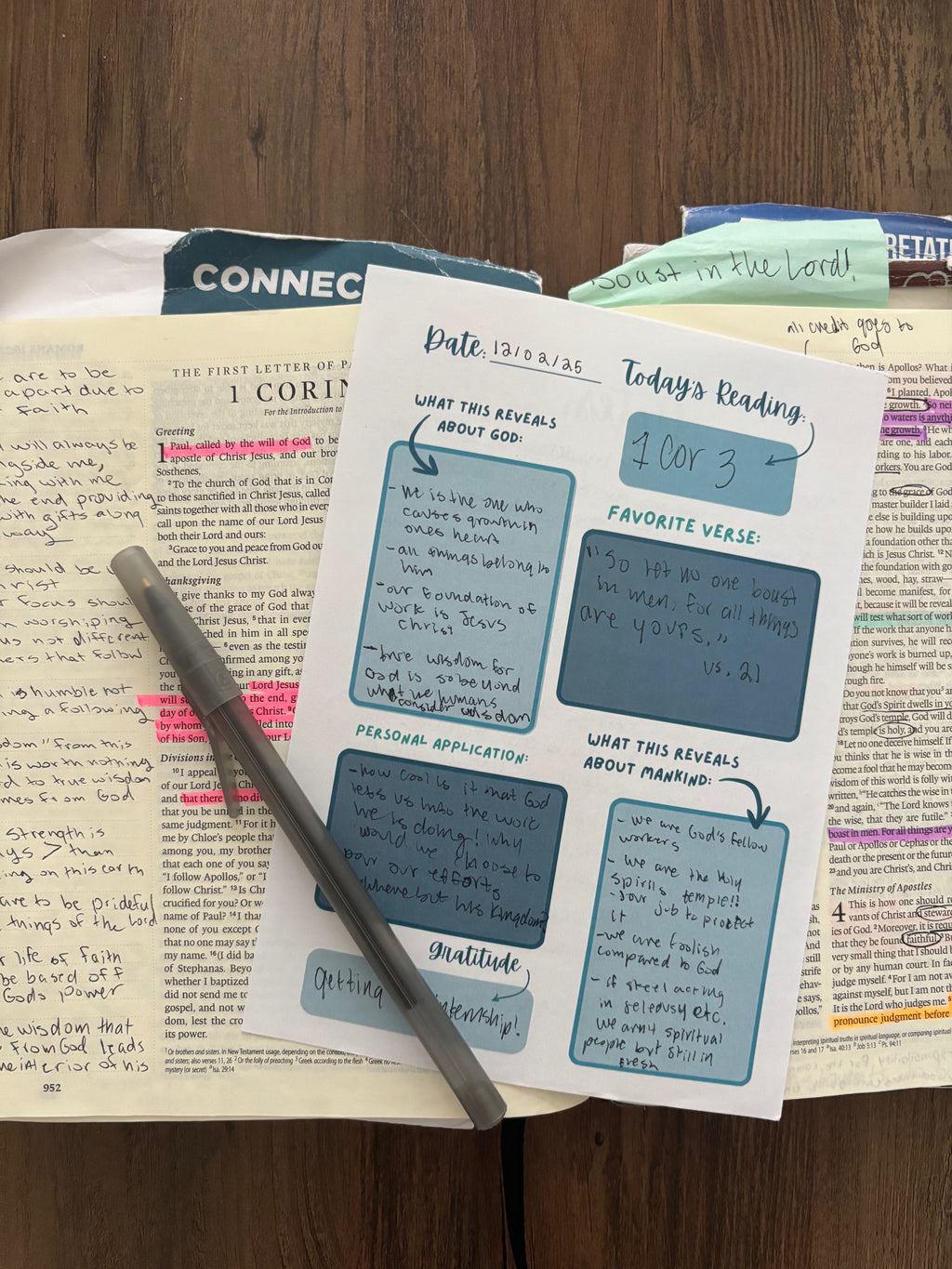 Bible open to a page with study notes and a pen on a wooden surface