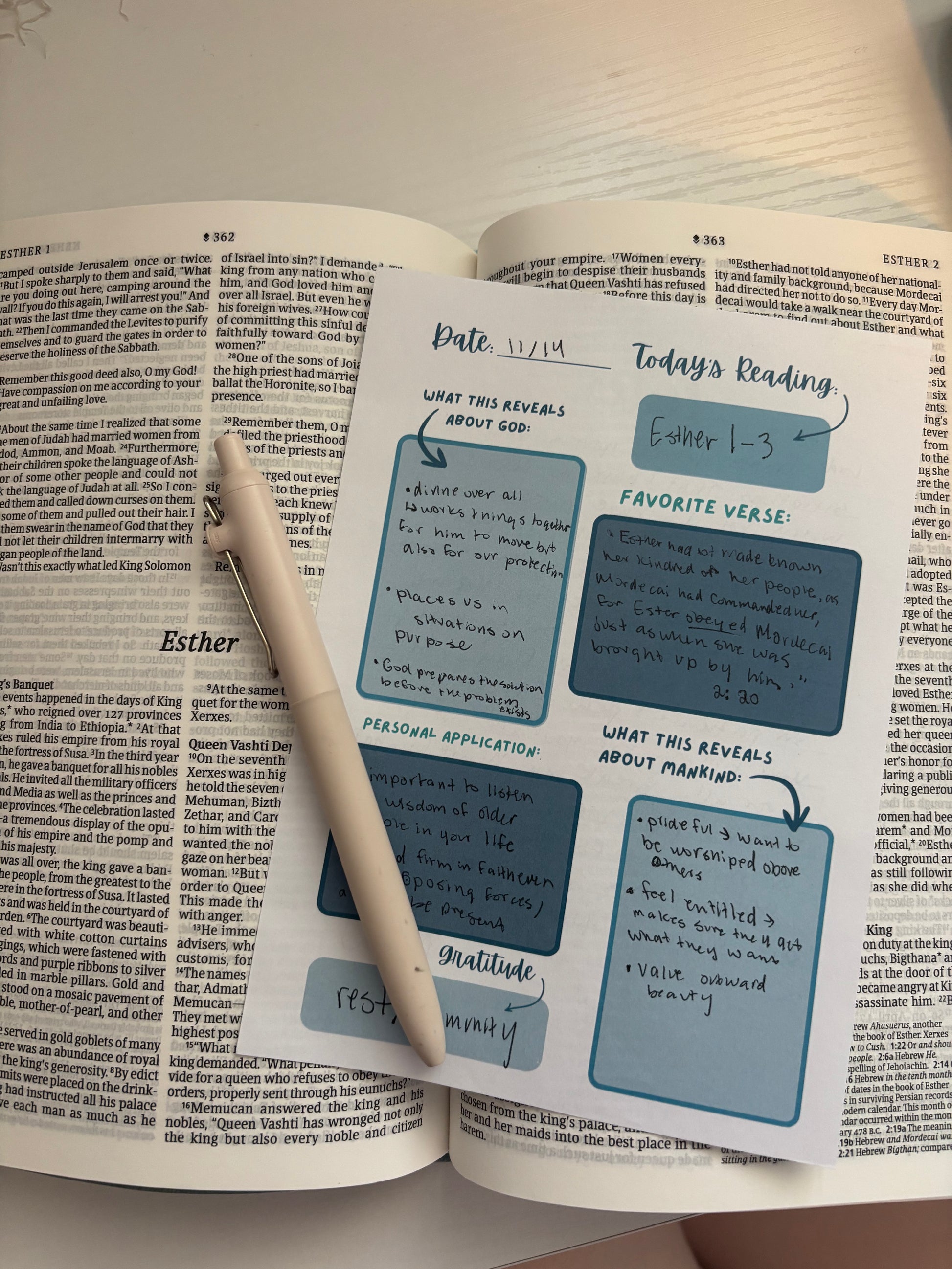 Open book with a pen on top, featuring a daily reading and reflection page.