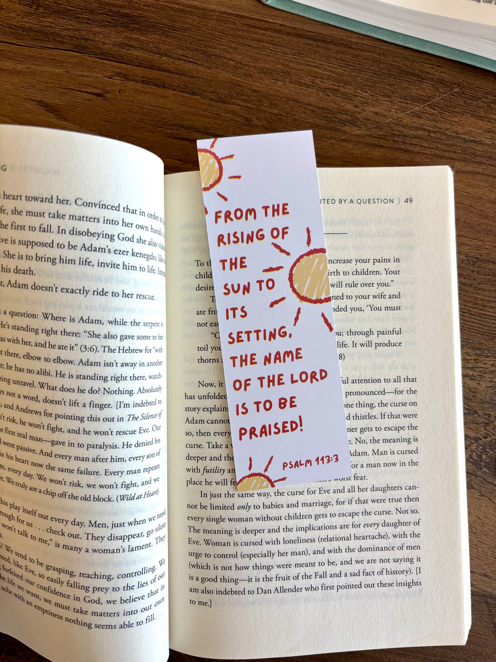 Book with a bookmark featuring Psalm 118:26 on a wooden surface