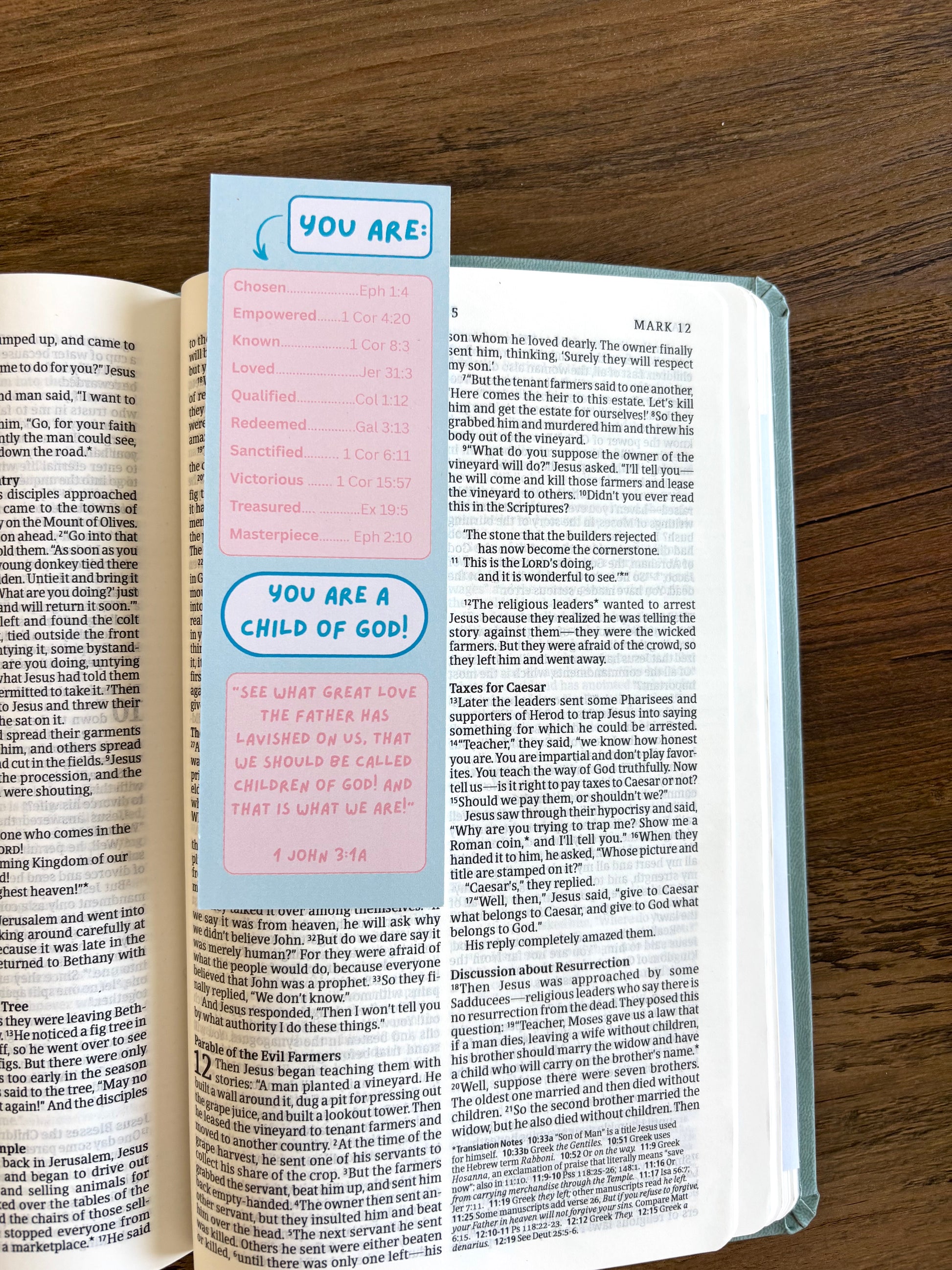 Open book with a colorful bookmark labeled 'You are a child of God' on a wooden surface