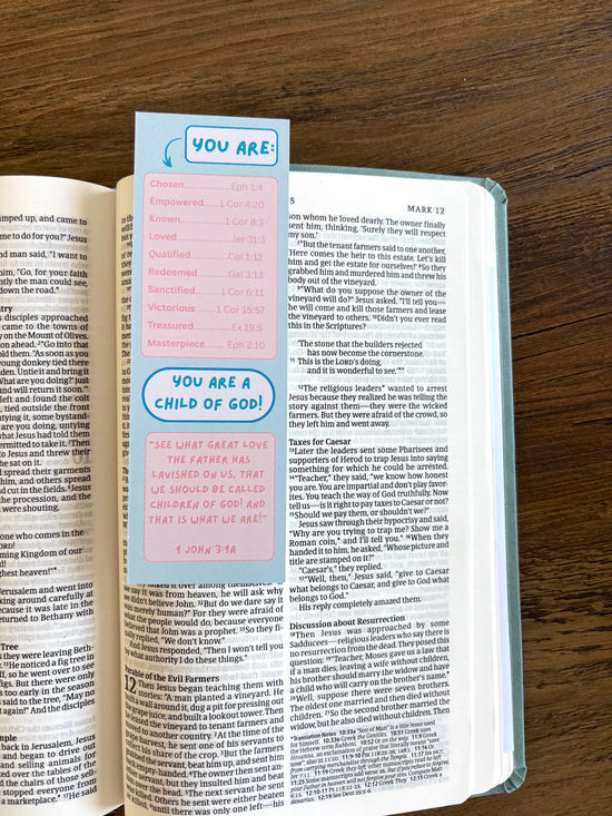 Open book with a colorful bookmark labeled 'You are a child of God' on a wooden surface