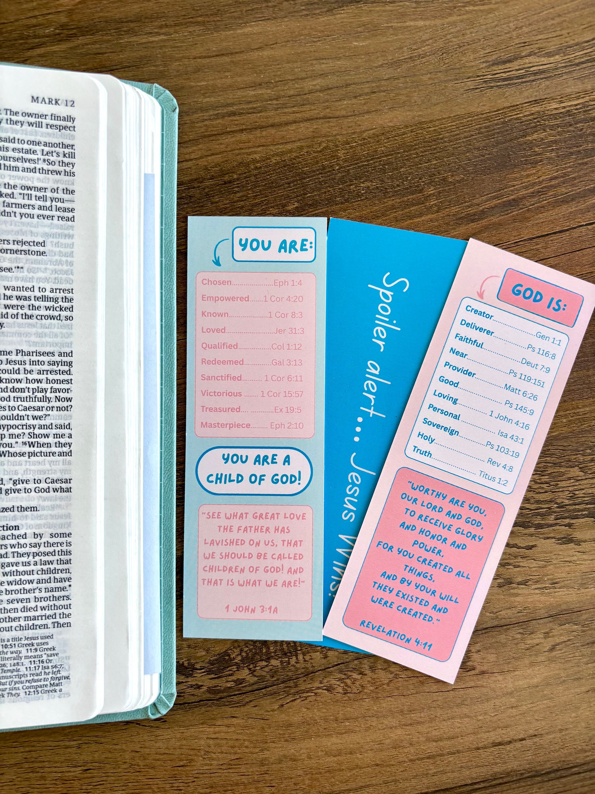 Bible with three colorful bookmarks on a wooden surface
