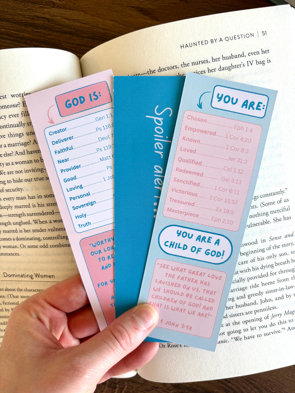 Three colorful bookmarks held over an open book