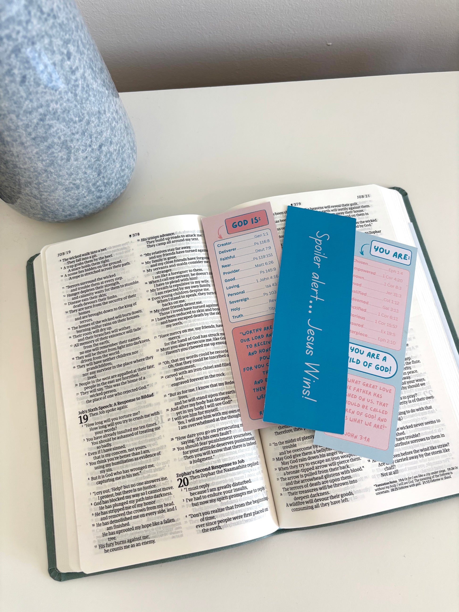 Open book with colorful bookmarks on a white surface