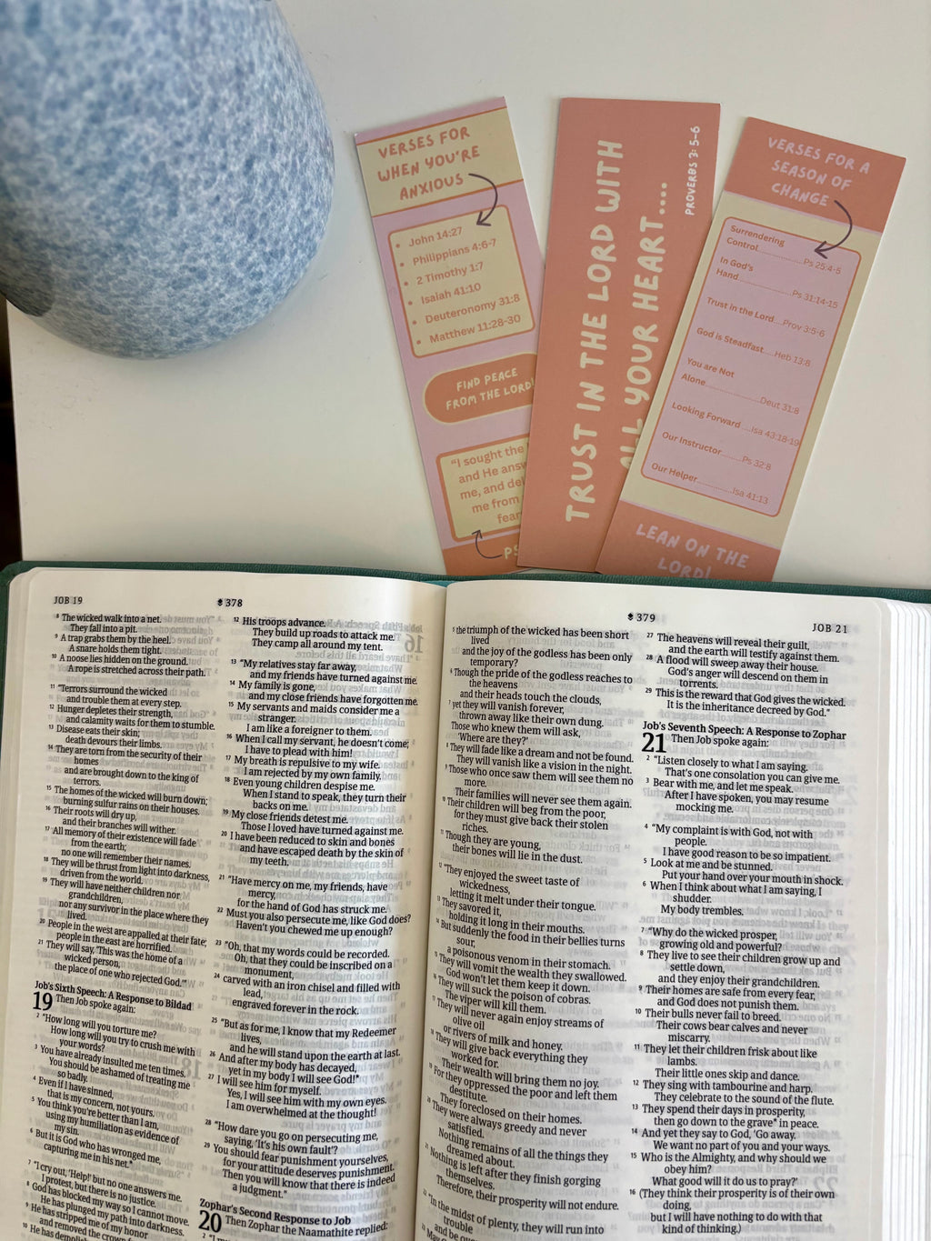 Open book with three bookmarks on a white surface