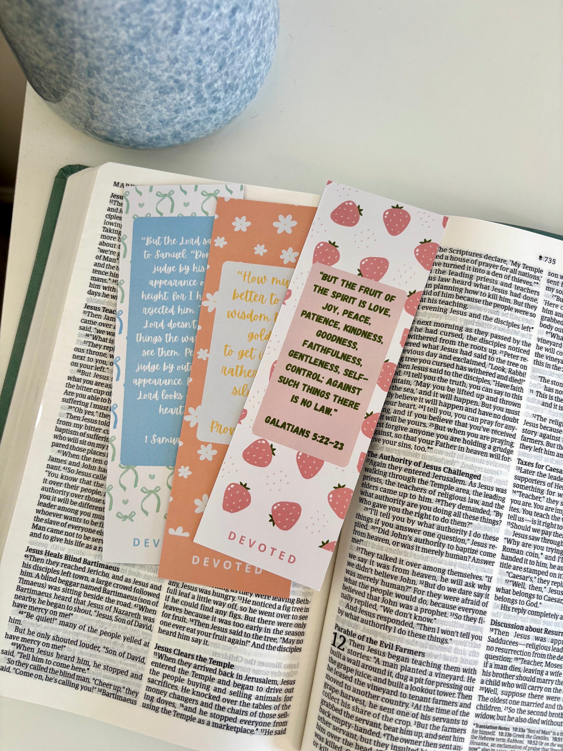 Open book with decorative bookmarks on a white surface