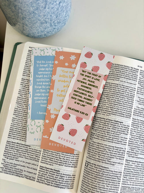 Open book with decorative bookmarks on a white surface