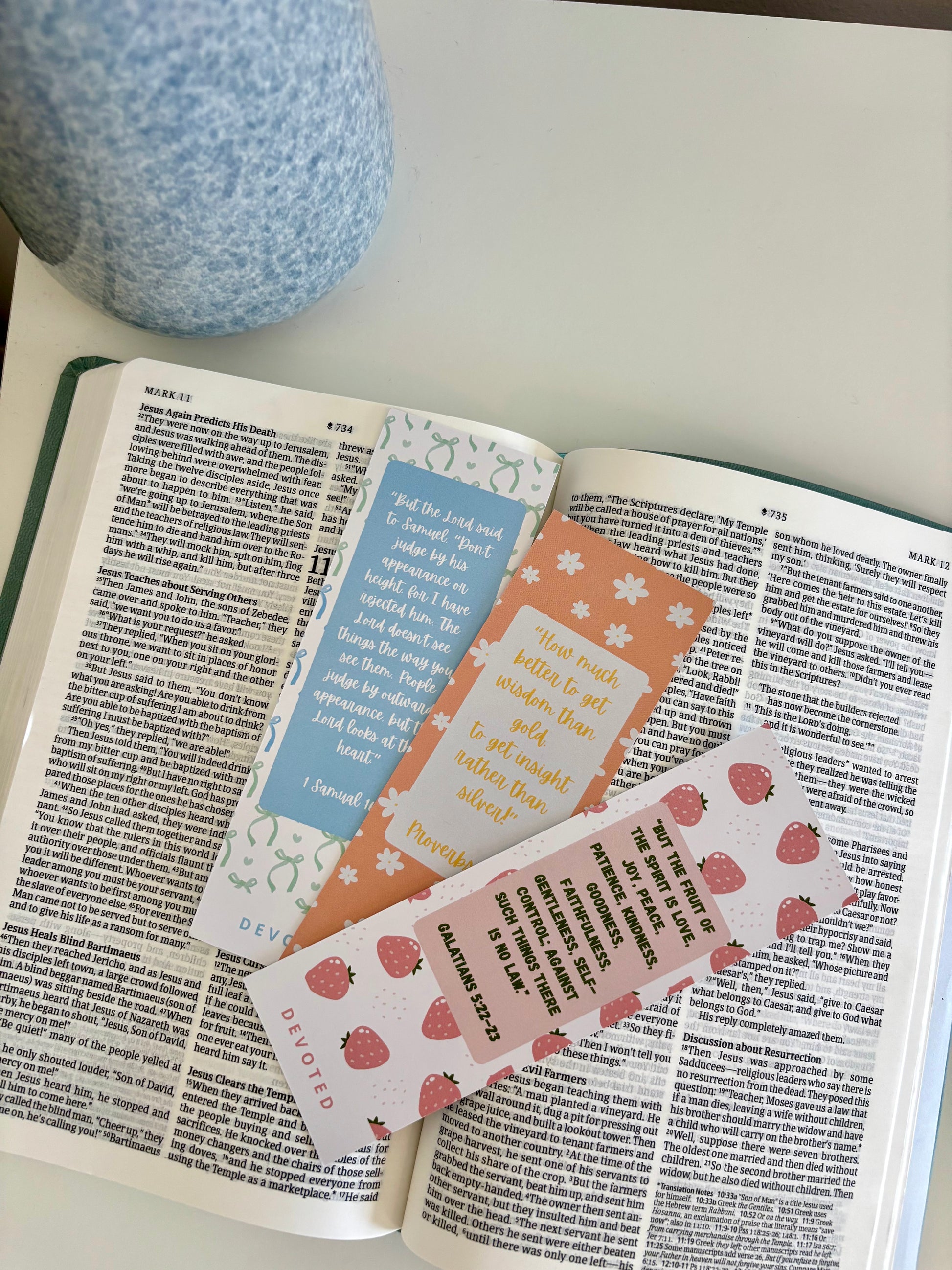 Open book with colorful bookmarks on a light surface
