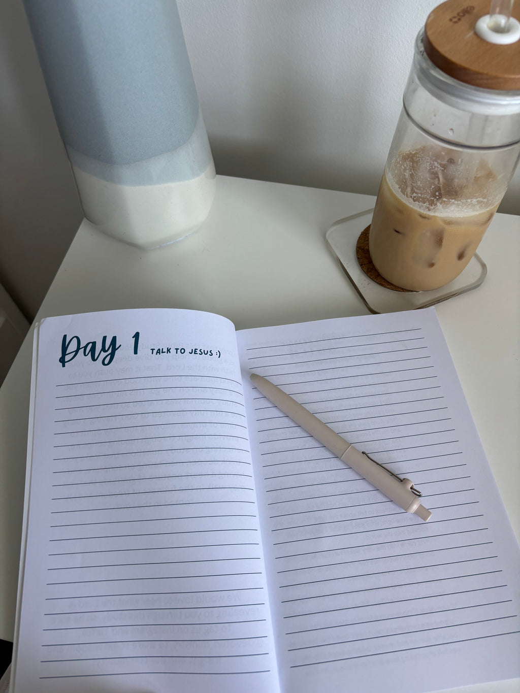 an open prayer journal book on a desk with a pen and coffee