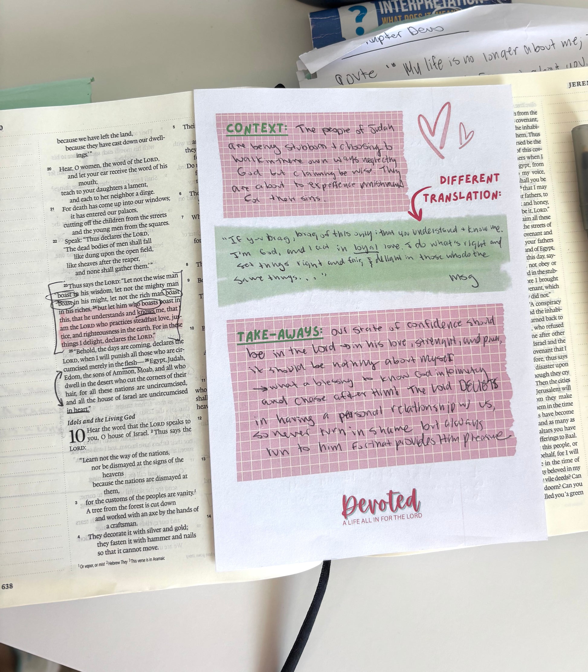 Notebook page with handwritten notes and a printed sheet titled 'Different Translation' on a white surface.