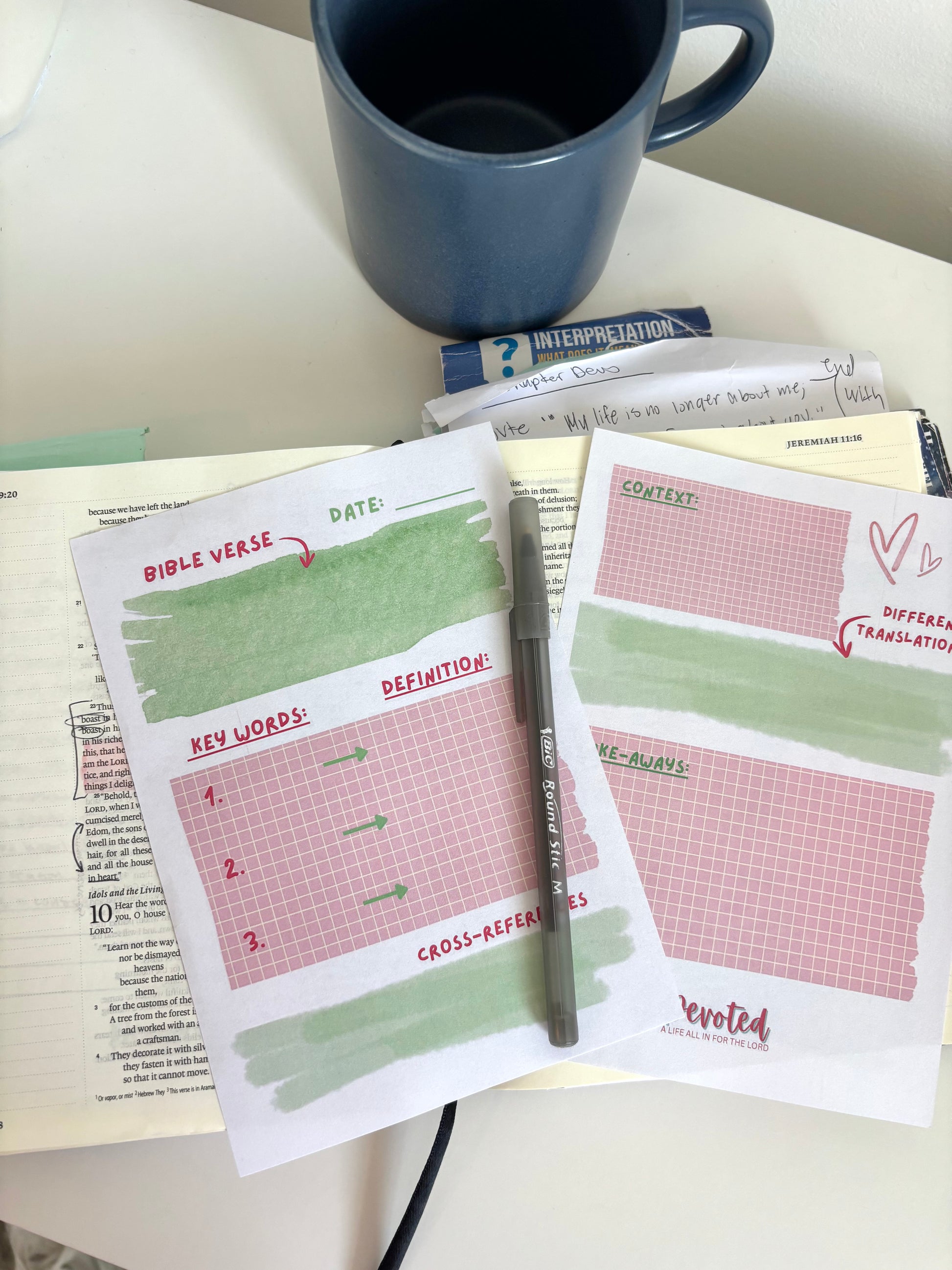 Printed sheets with Bible study tools on a desk with a pen and mug.