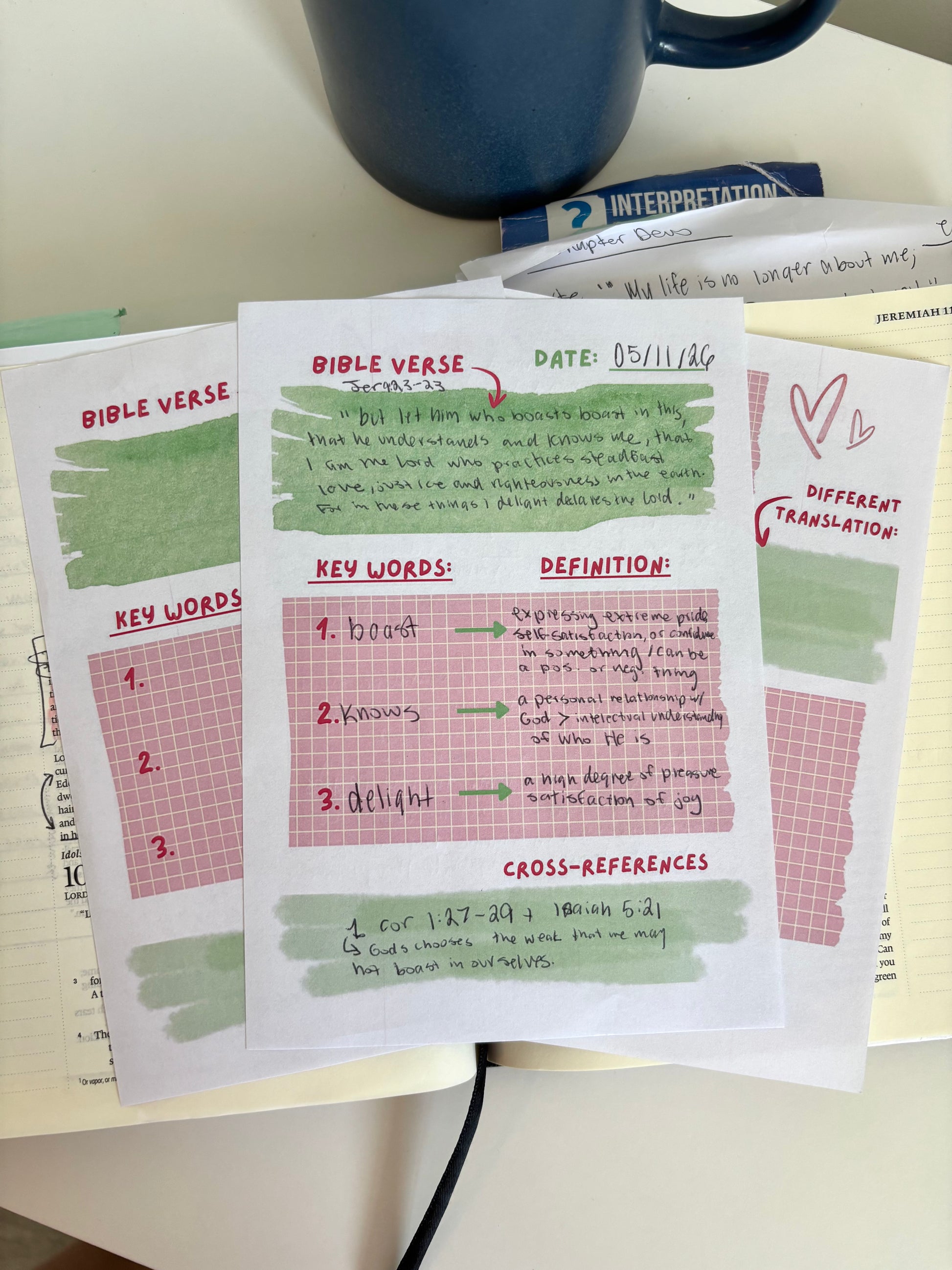 Sheet of paper with Bible verse study guide on a table with a blue mug.