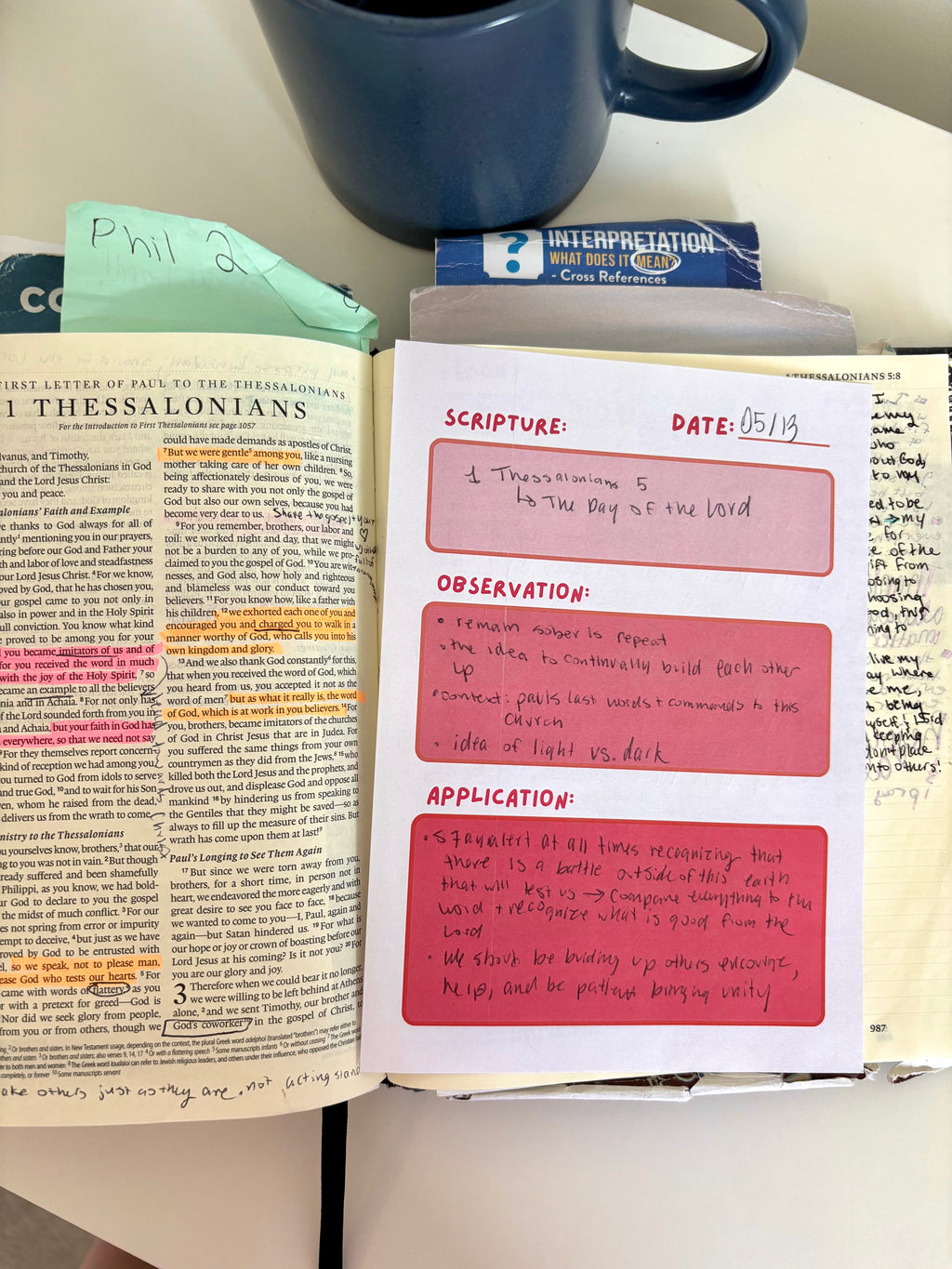 Open book with notes and a cup of coffee on a table