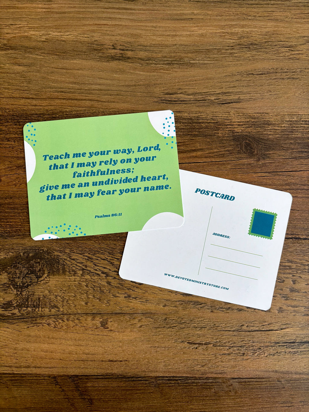 green postcard with a bible verse on it displayed on a brown wooden table