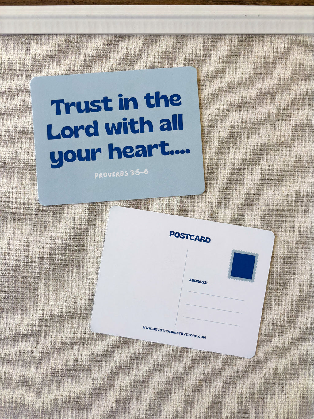 A postcard-style magnet or card set on a beige fabric surface, showing the front with the text 'Trust in the Lord with all your heart.
