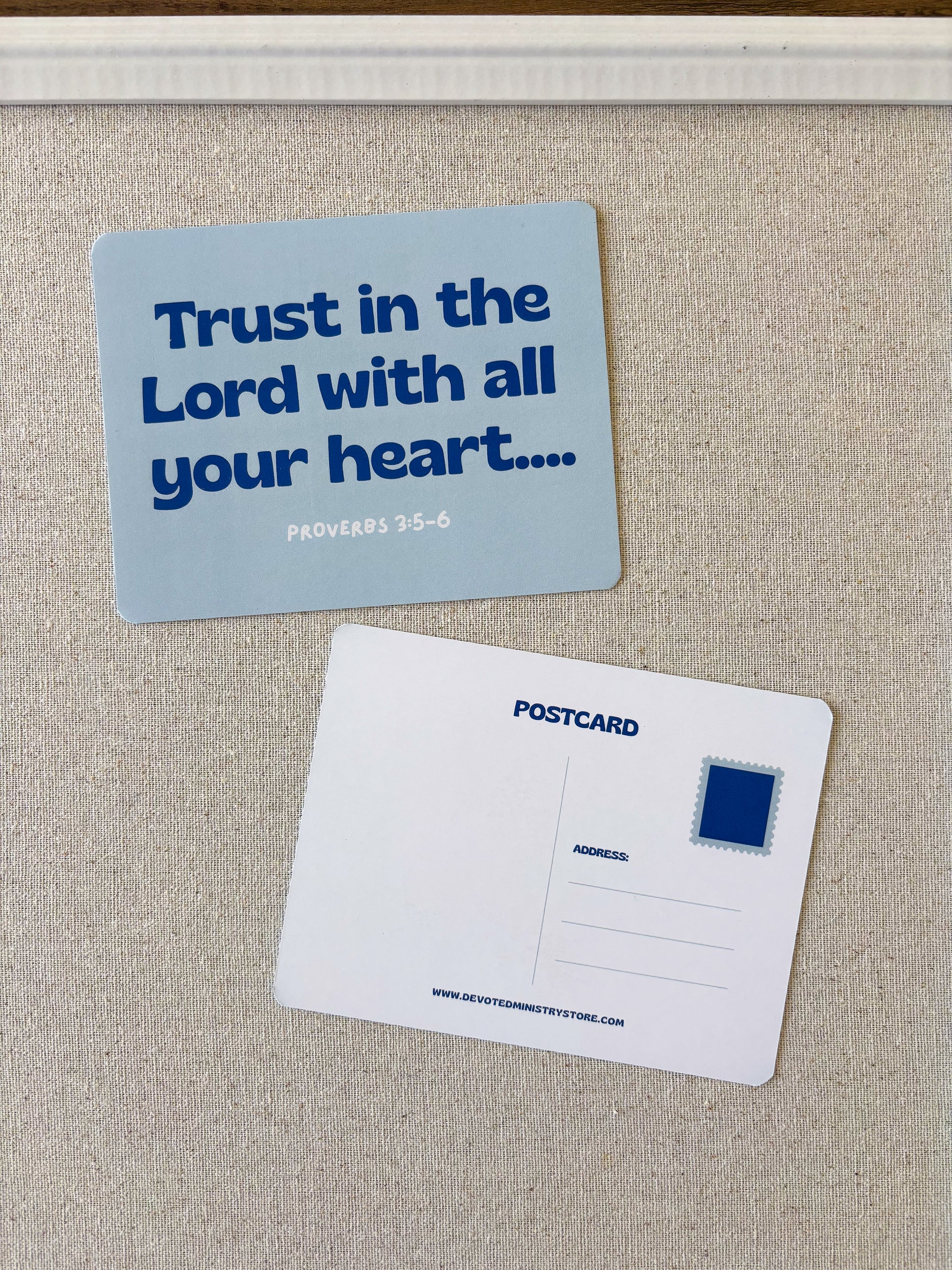A postcard-style magnet or card set on a beige fabric surface, showing the front with the text 'Trust in the Lord with all your heart.