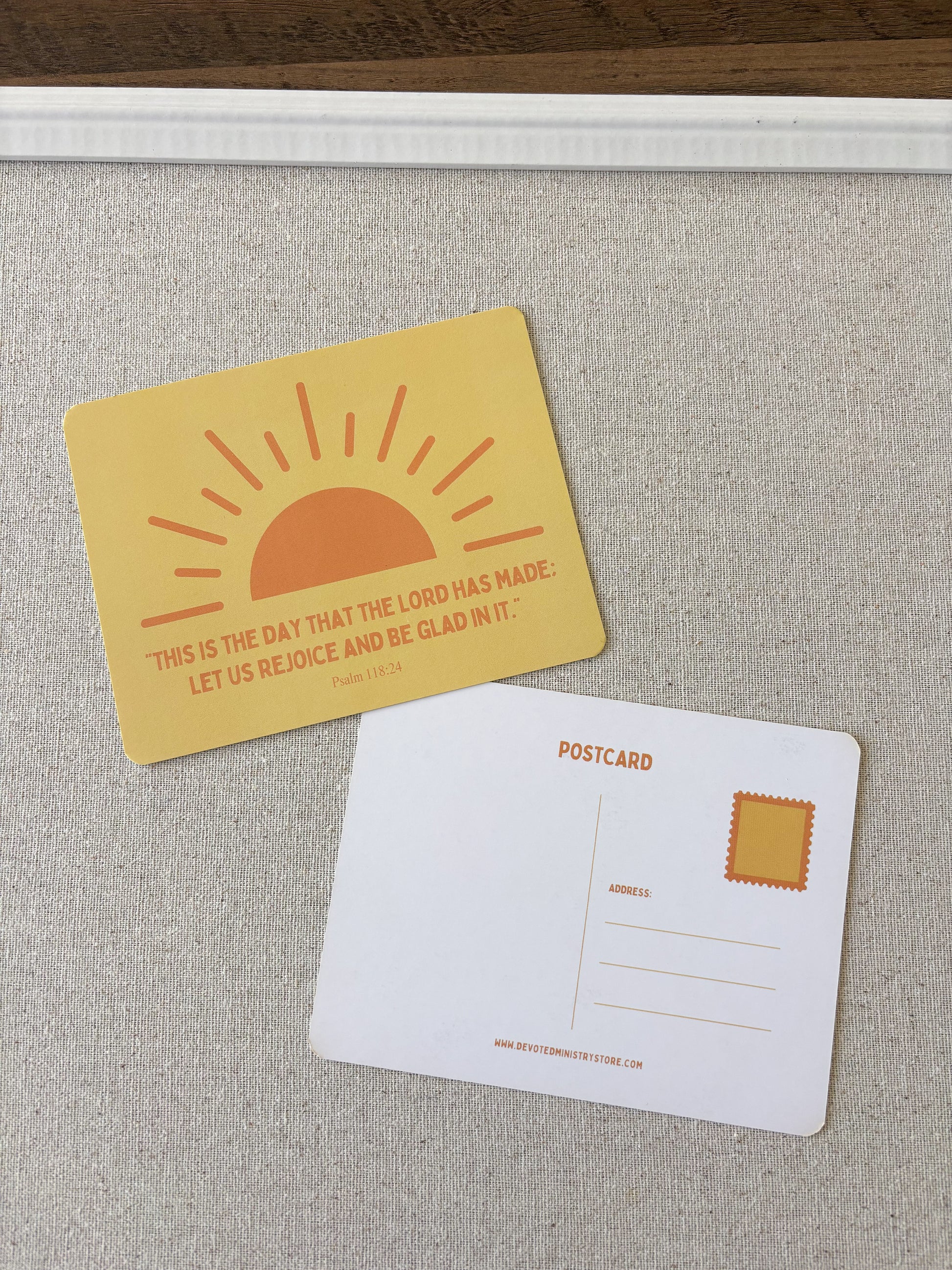 A postcard set featuring a yellow front with an orange rising sun and the quote 'THIS IS THE DAY THAT THE LORD HAS MADE. LET US REJOICE AND BE GLAD IN IT.