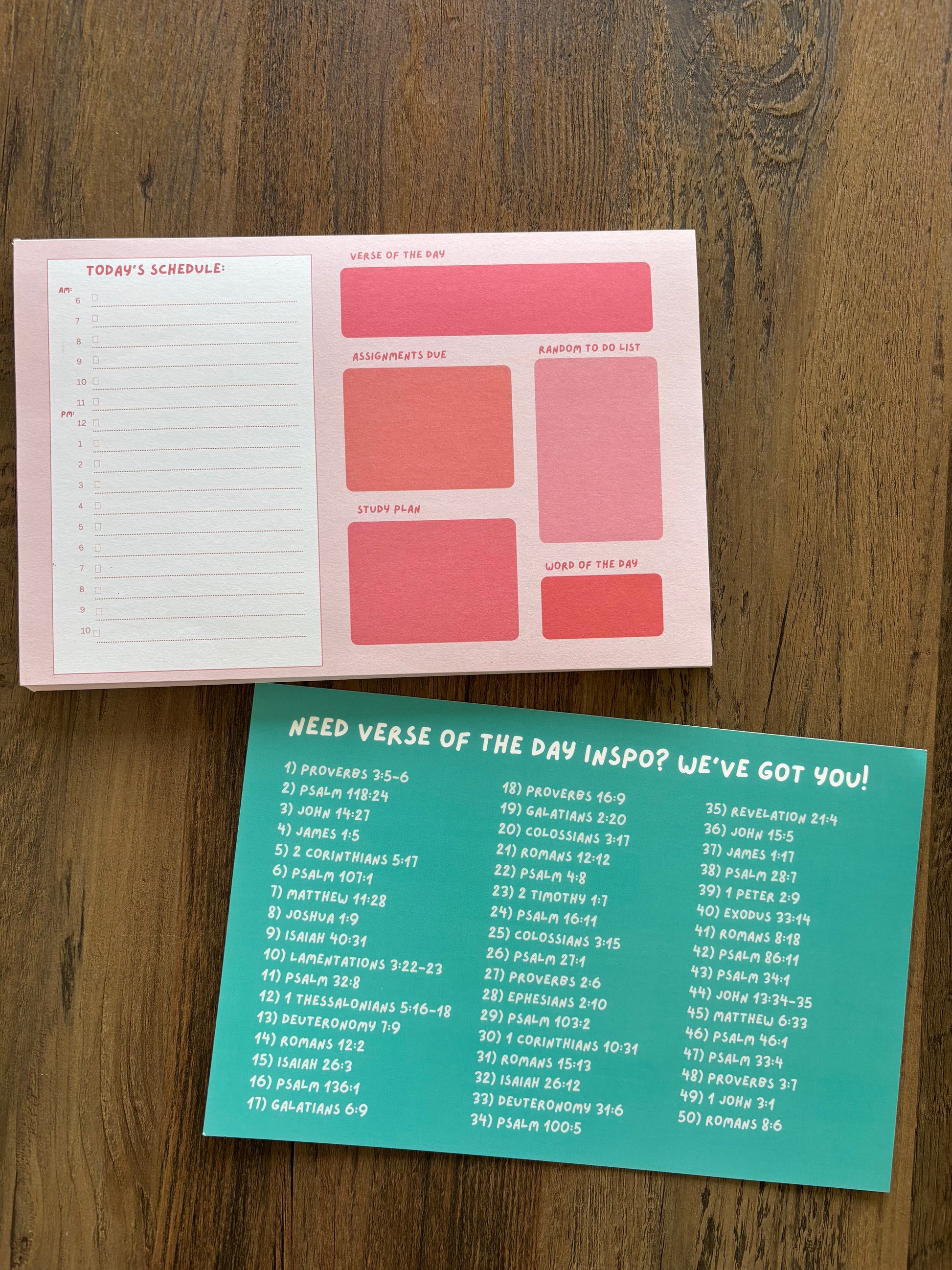 pink college daily planner laying down on a brown wooden table