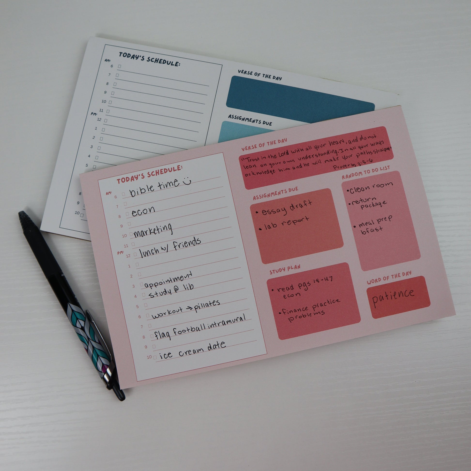 college daily planners displayed on a white table with a pen 