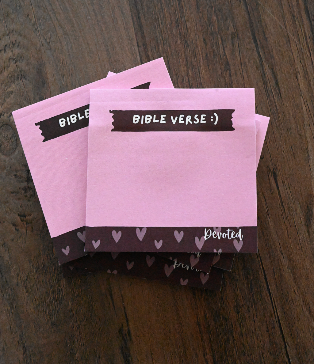 Pink notepads with 'Bible Verse' text on a wooden surface