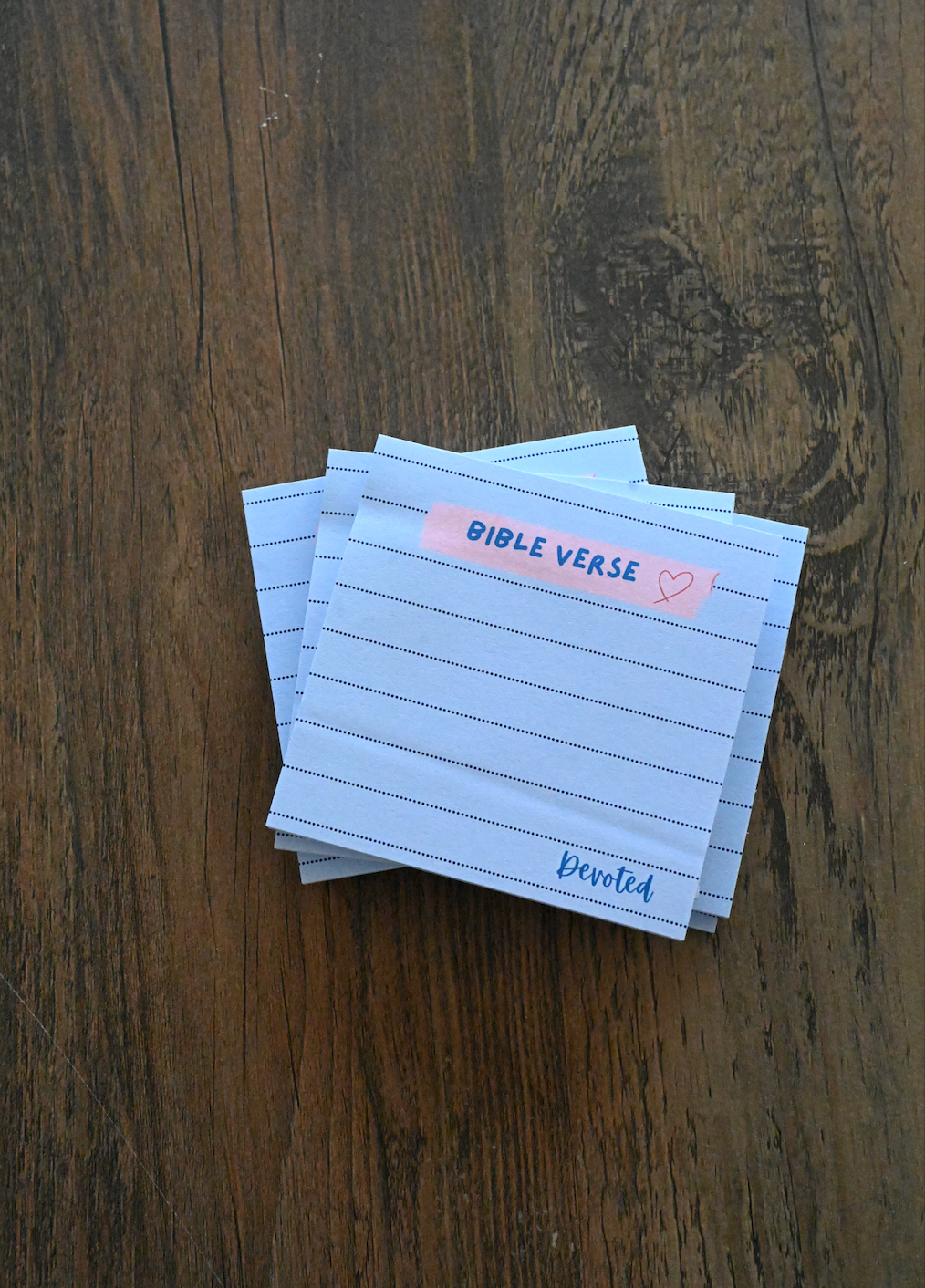 Stack of lined cards with 'Bible Verse' and 'Devoted' text on a wooden surface