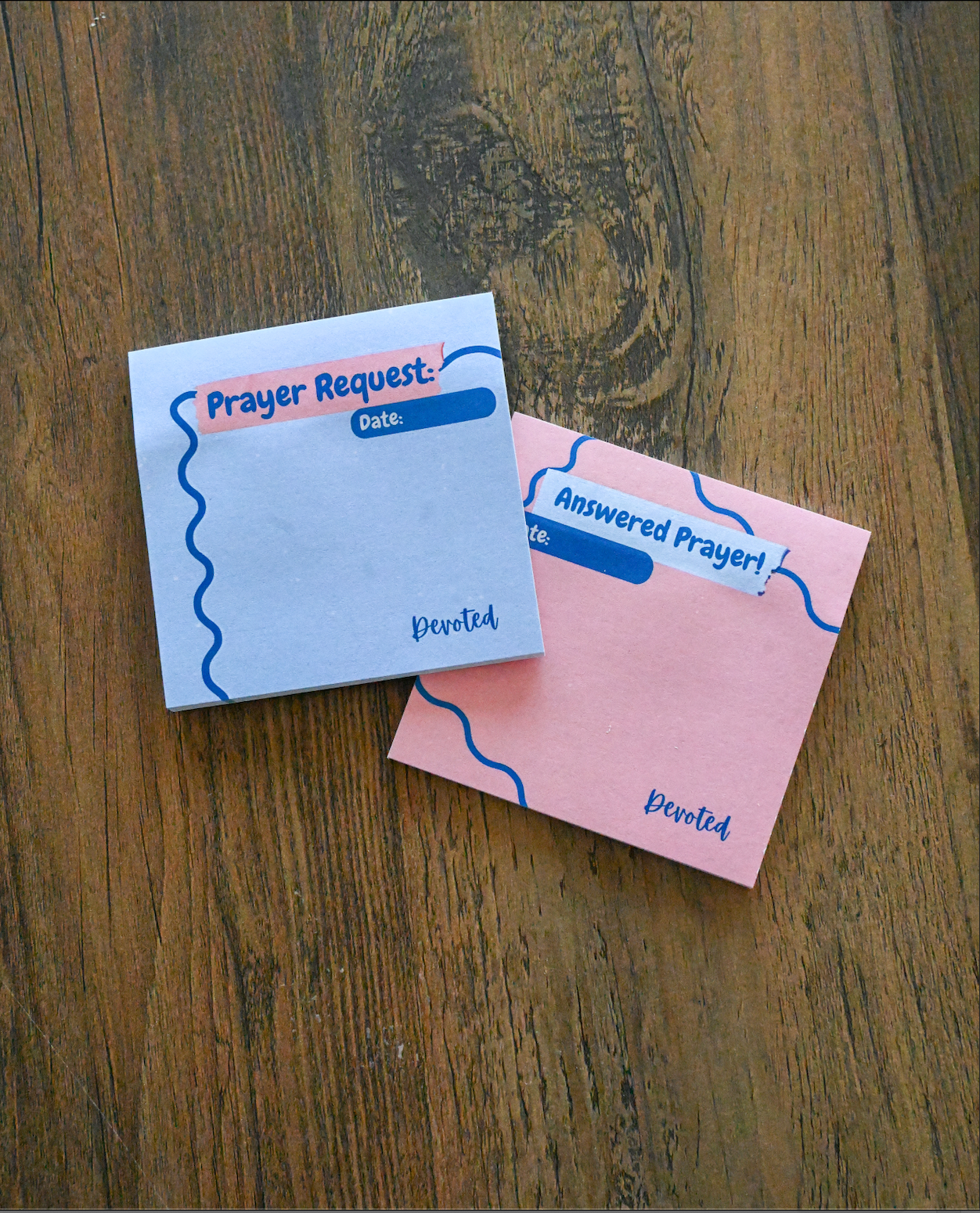 Two prayer request sticky notes on a wooden surface