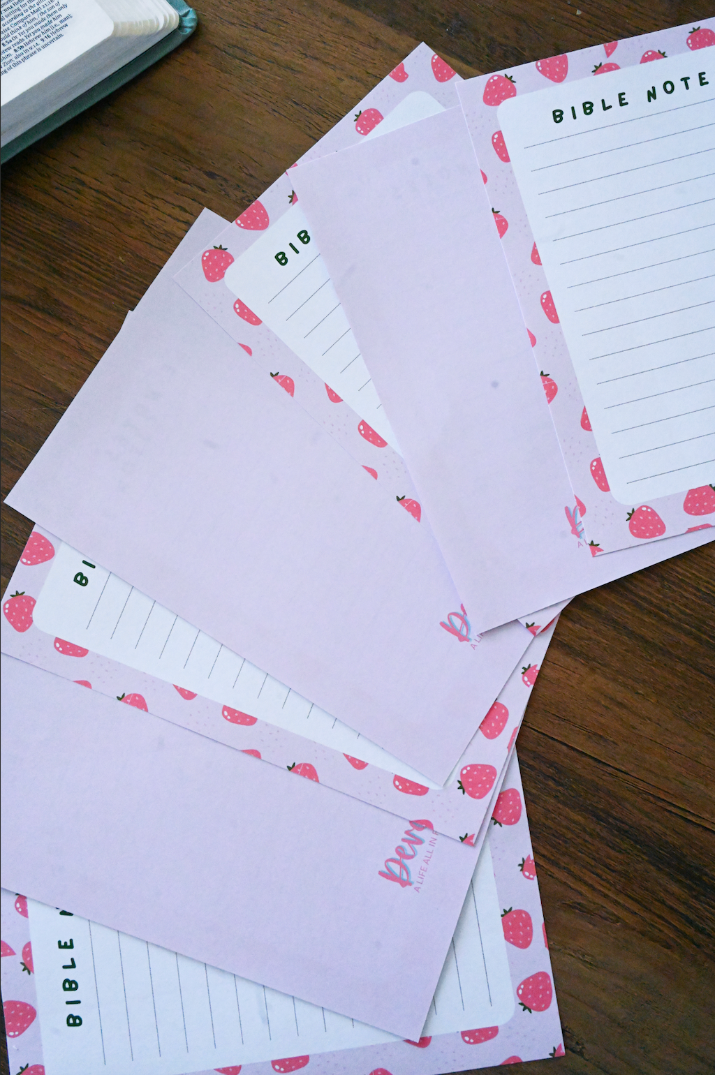 Set of stationery items with strawberry pattern on a wooden surface